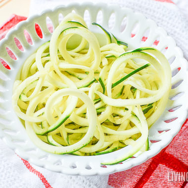 A close up of zucchini noodles on white plate
