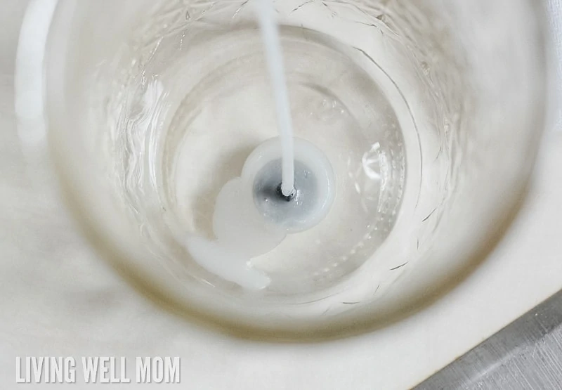 a wick stuck to the bottom of a jelly jar