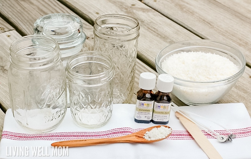 four empty glass jars next to ingredients for DIY candle-making