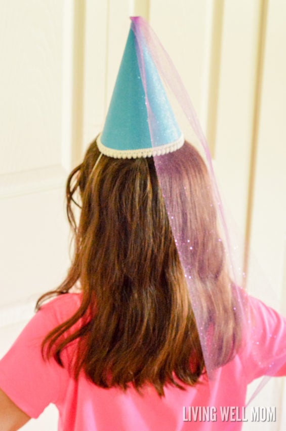a girl with long brown hair and blue DIY princess hat craft