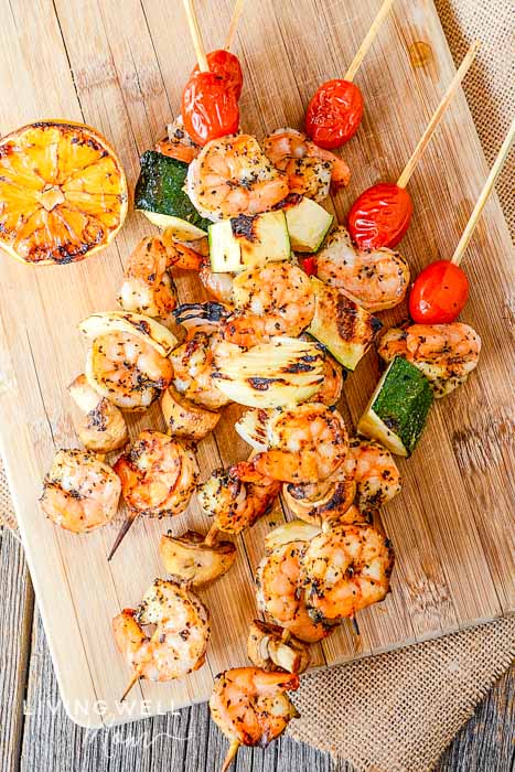Grilled shrimp skewers with lemon, tomatoes, and zucchini 