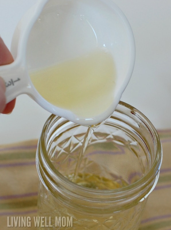pouring castile soap into a mason jar for honey face wash recipe