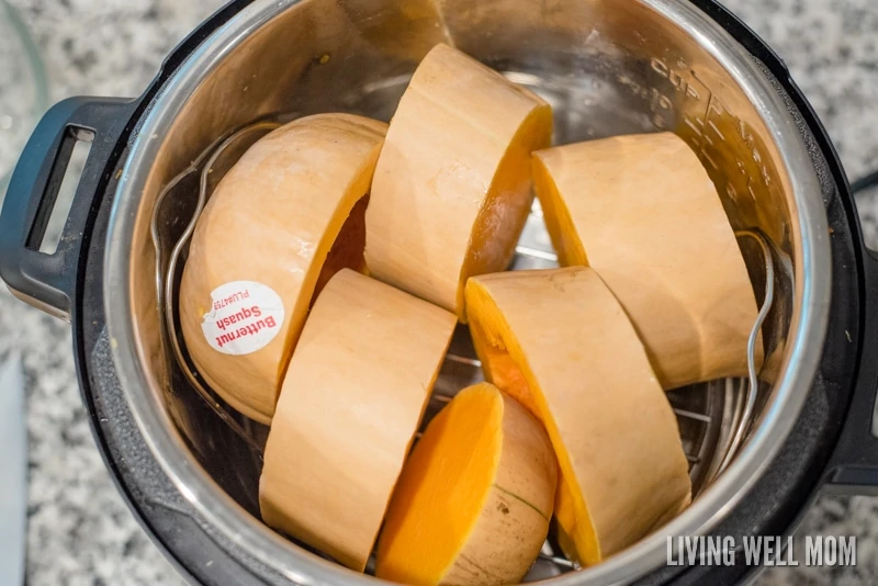 Slices of butternut squash tightly placed inside pressure cooker.