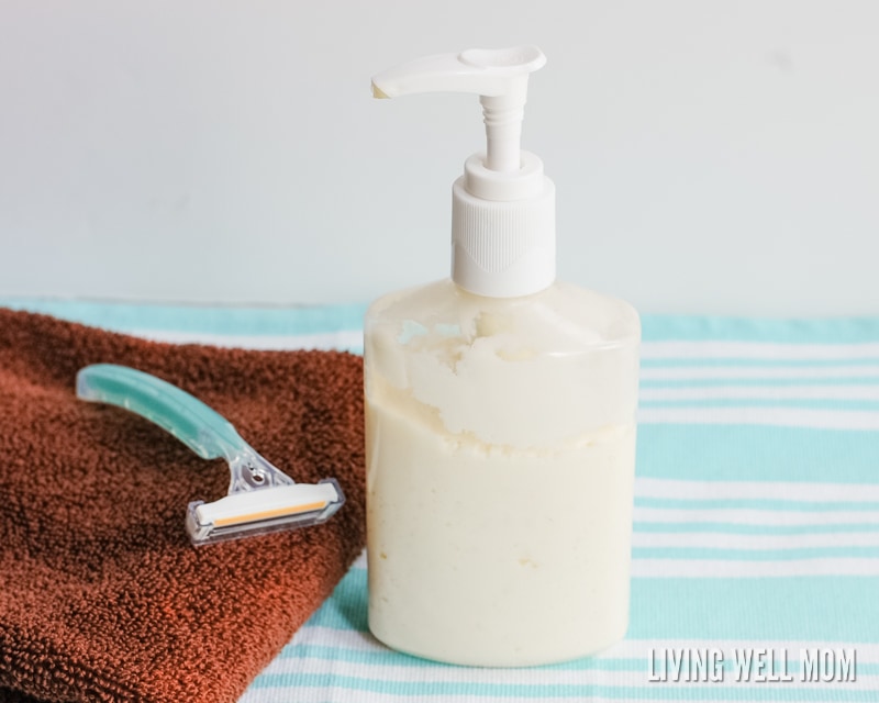 shaving cream in a pump bottle next to a razor on a brown towel