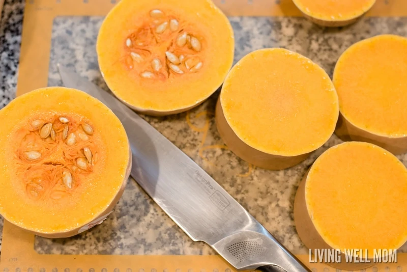 Squash cut into small rounds on a cutting mat.