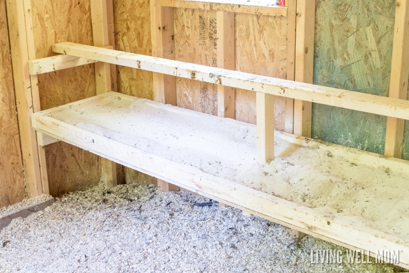 dropping board inside of a wooden chicken coop