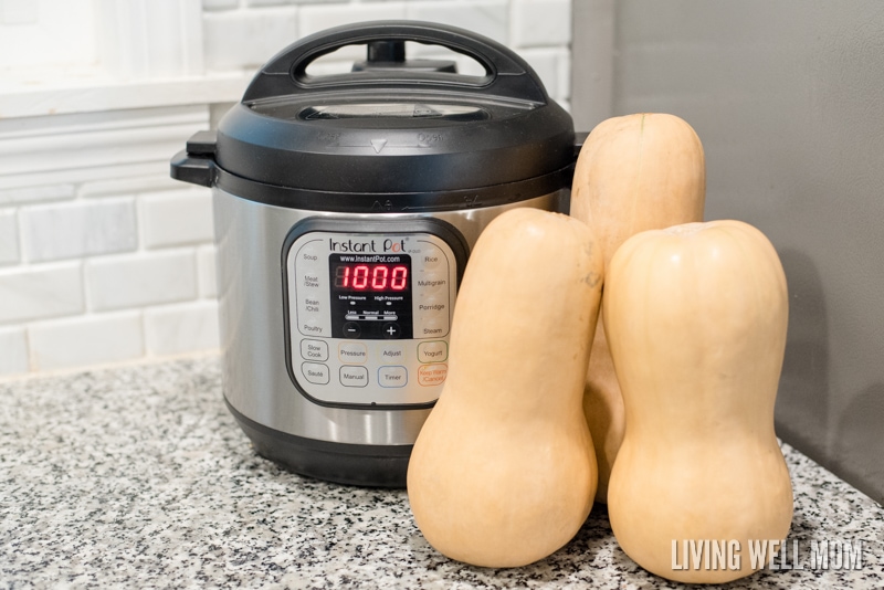 Three butternut squashes next to an instant pot ready to be cooked. 