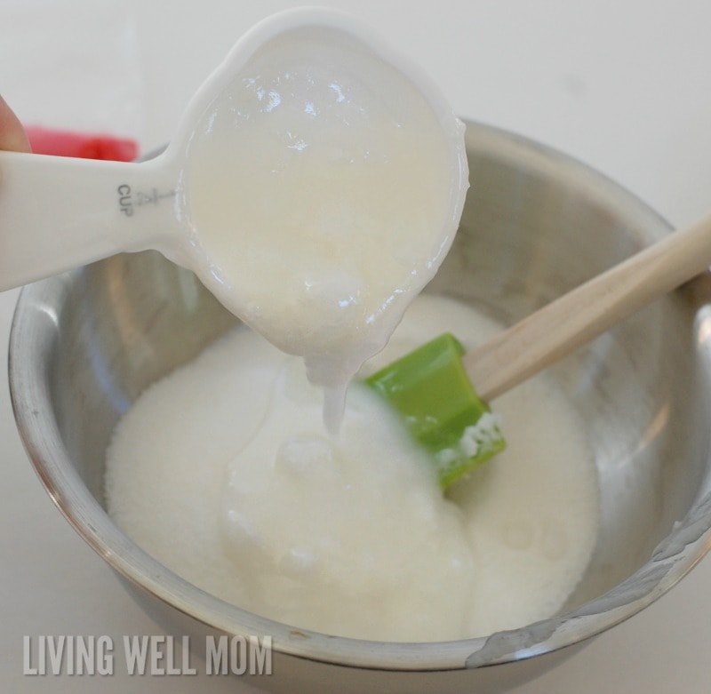 coconut oil being poured into a bowl of fine grain sugar