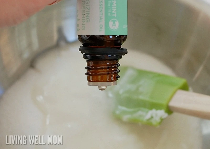 putting peppermint essential oil drops  into homemade sugar scrub recipe