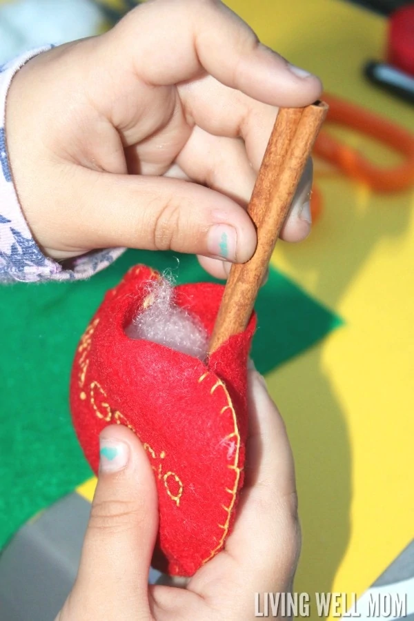 These Felt Apple Ornaments are easy for kids to put together and they have a secret - they're cinnamon-scented! Perfect for a homemade teacher gift, these DIY ornaments are a great craft activity for kids or a first sewing project.