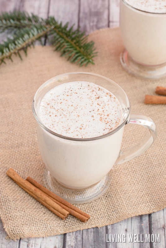 mug of creamy homemade vegan eggnog with cinnamon sticks beside it