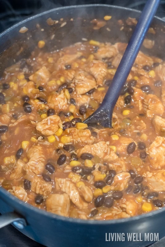 A large spoon stirring casserole mixture on the stove. 