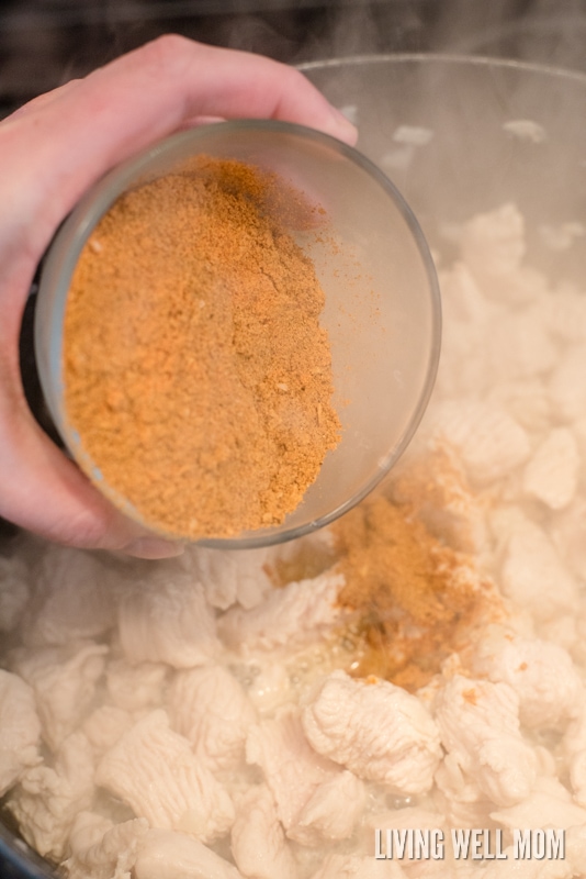 Taco seasoning being added into meat for enchilada casserole. 