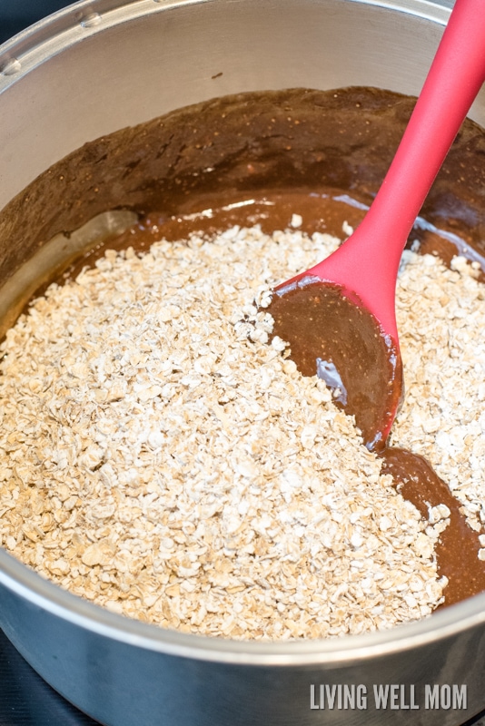 oats being folded into chocolate no bake cookie mixture with a red spoon