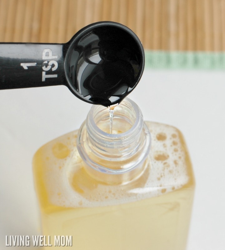 black teaspoon pouring soap into plastic soap container