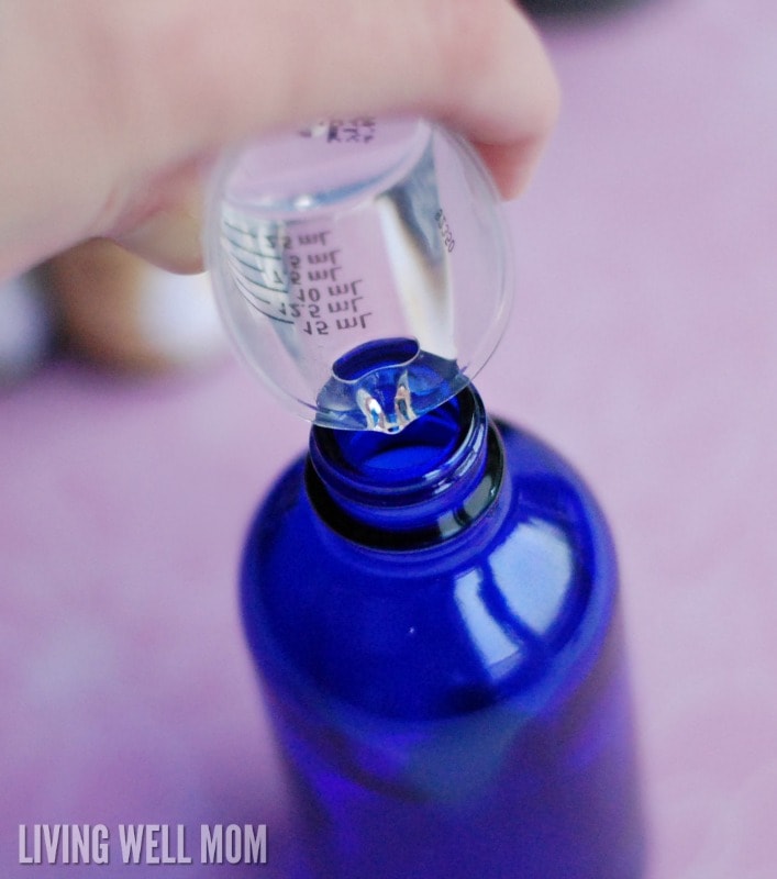 pouring ingredients into blue glass bottle
