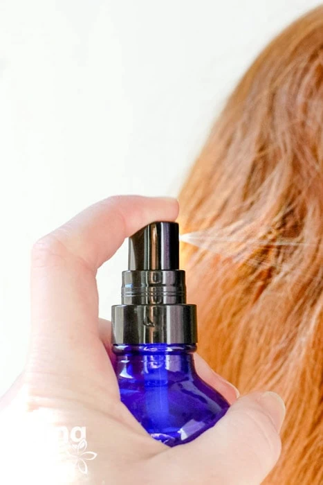 spraying DIY hair detangler into hair