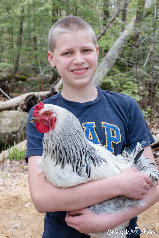 a boy holding a rooster 
