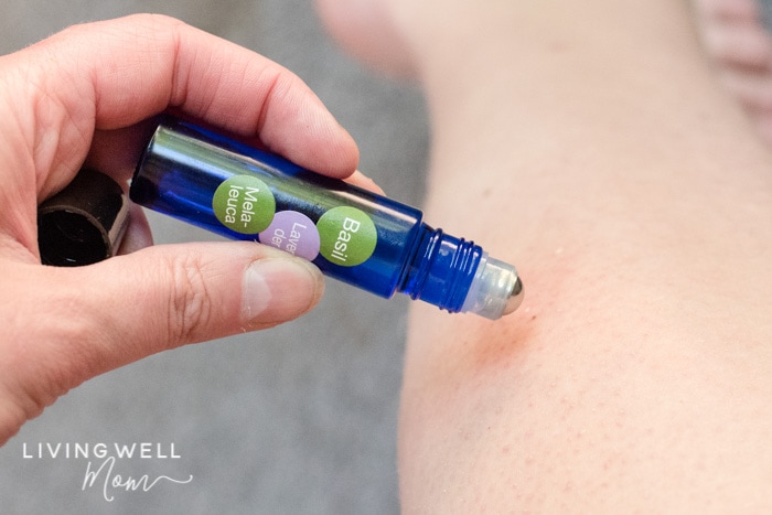 essential oil roller being used on leg for itchy mosquito bite