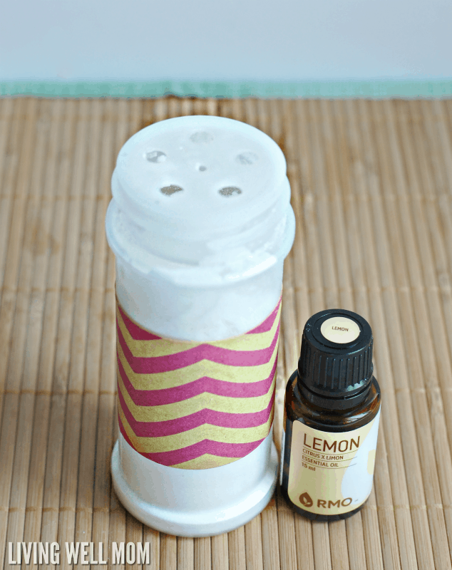a reused spice jar with baking soda deodorizing mixture inside, and a bottle of lemon essential oil. 
