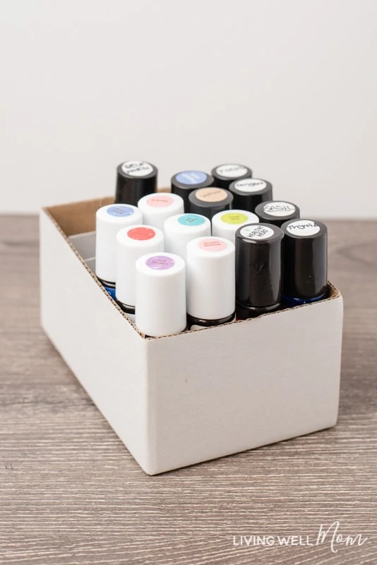 filled essential oil roller bottles with labels in a white cardboard box with dividers