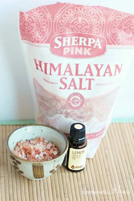bag of pink Himalayan salt, salt in a bowl, and a bottle of lemon essential oil.