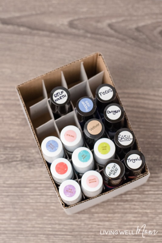 filled essential oil roller bottles with labels in a white cardboard box with dividers