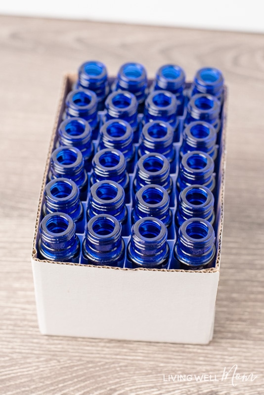 blue essential oil roller bottles with no caps in a white cardboard box
