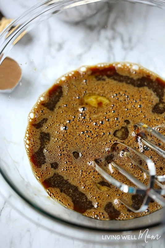 mixing molasses and eggs for gingerbread muffins