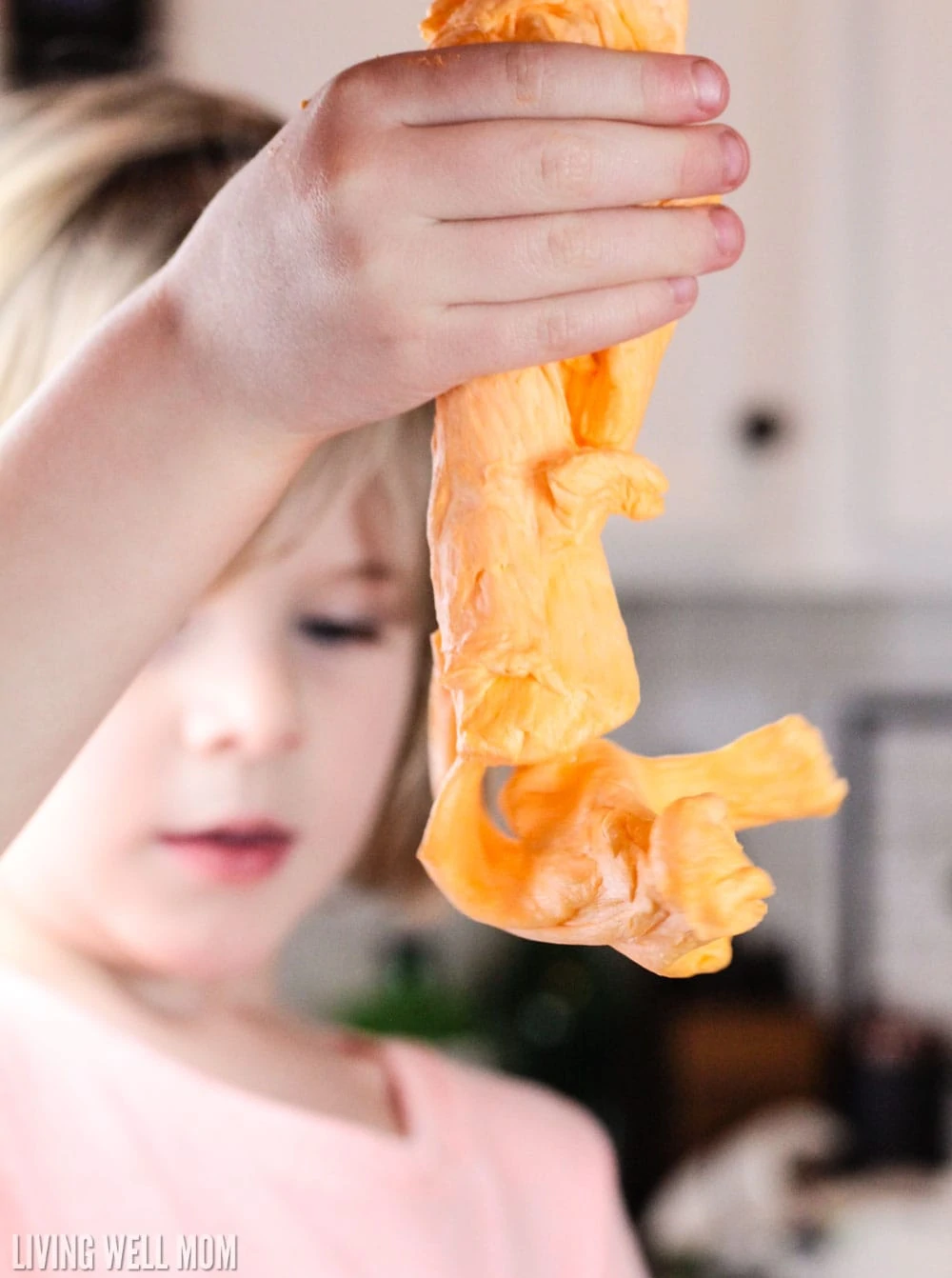 Child playing with orange fluffy slime