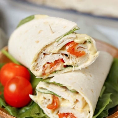 With delicious maple honey turkey slices, spinach, tomatoes, hummus, mayo, and Dijon mustard layered in a wrap, this Healthy Spinach Turkey Wrap is as satisfying and filling as it is tasty. It's a delicious, good-for-you alternative to the boring sandwiches or other common lunches we often eat. #healthyrecipes #lunch #easyrecipe