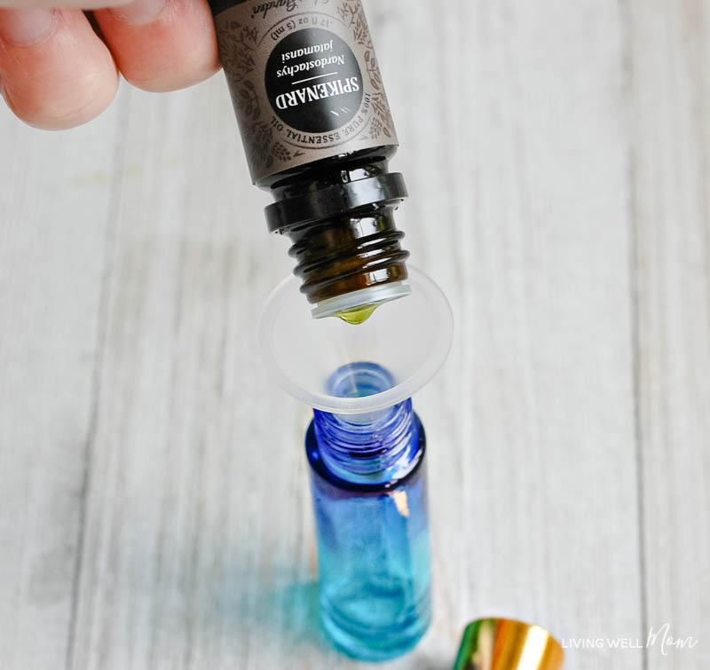 adding spikenard essential oil to a roller ball to create a relaxing essential oil blend