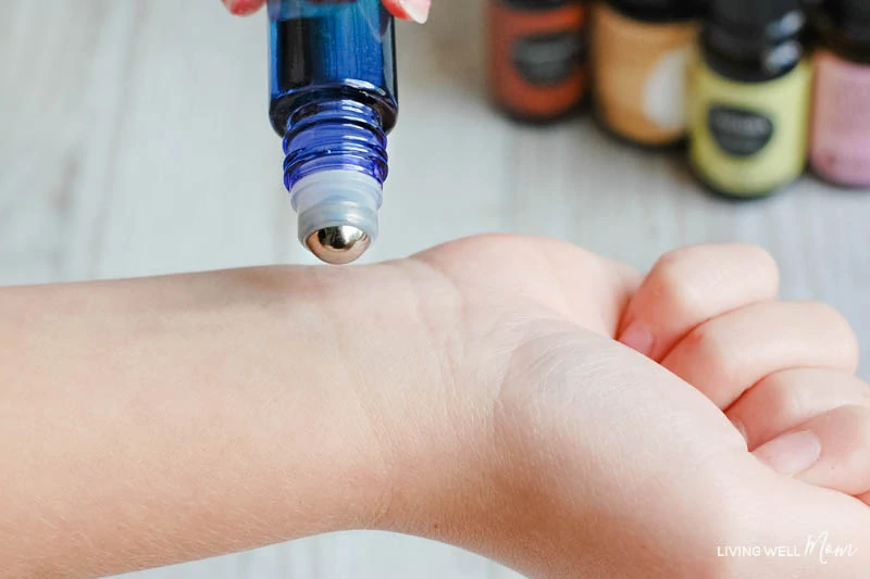 roller bottle applying calming oils to child's wrist