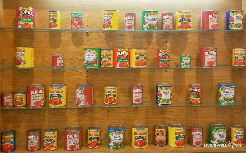 different Red Gold and Red Pack canned tomato products lining shelves on a wall