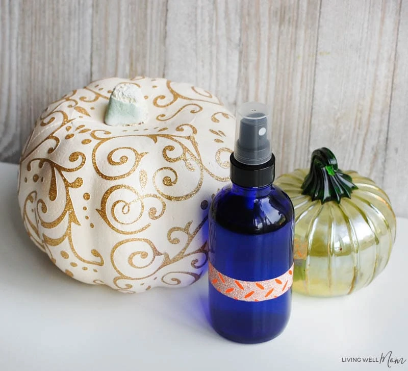 a spray bottle and two pumpkins on a table 