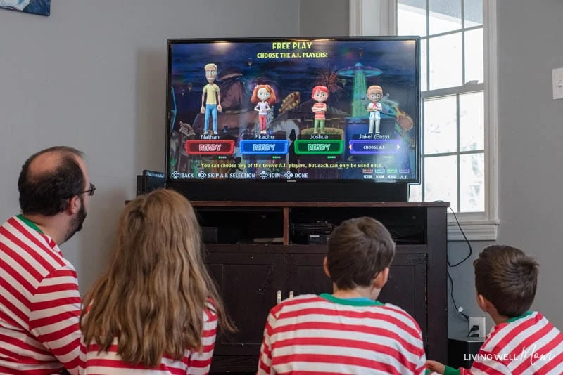 A group of people sitting in front of a television playing a Carnival game 