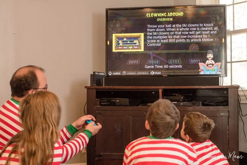 A group of people standing in front of a television playing a Carnival game 