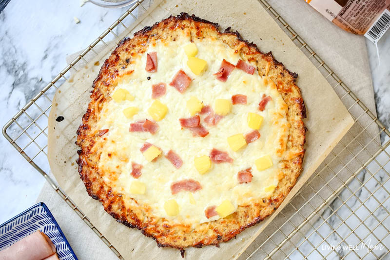 A Hawaiian pizza topped with mozzarella cheese, ham and pineapple tidbits. 