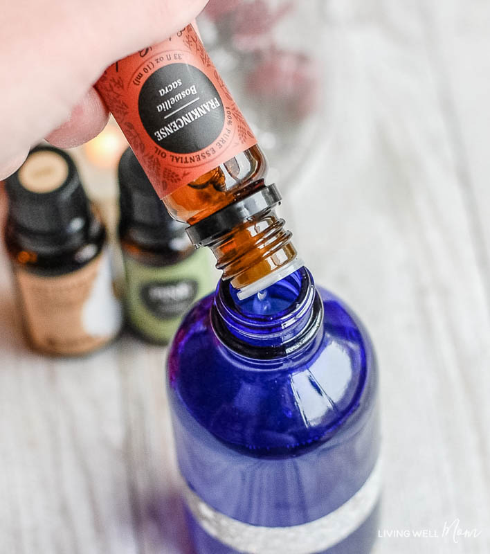 A close up of some essential oils being poured into a spray bottle