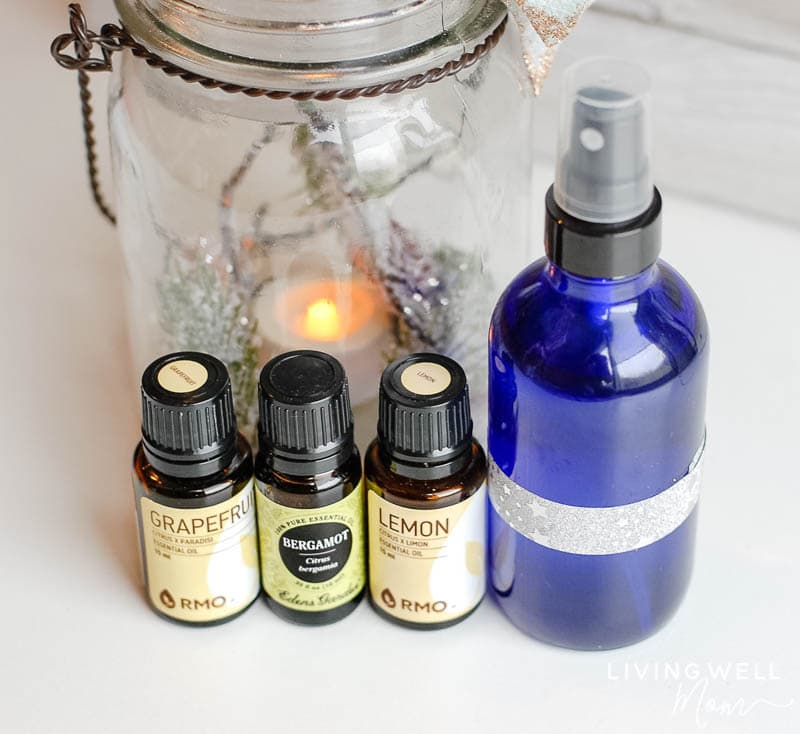 some essential oils, a spray bottle, and a glass jar 