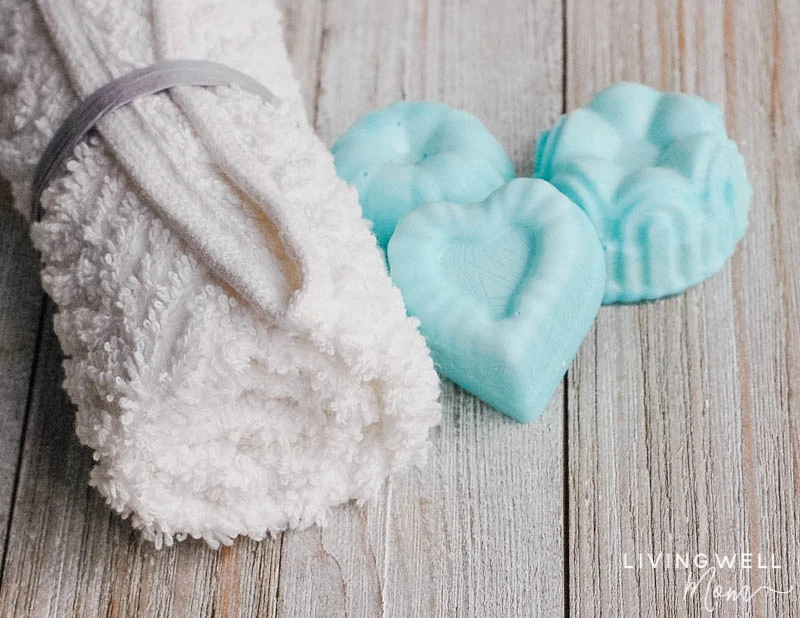 rolled white towel with blue heart shaped essential oil shower melts