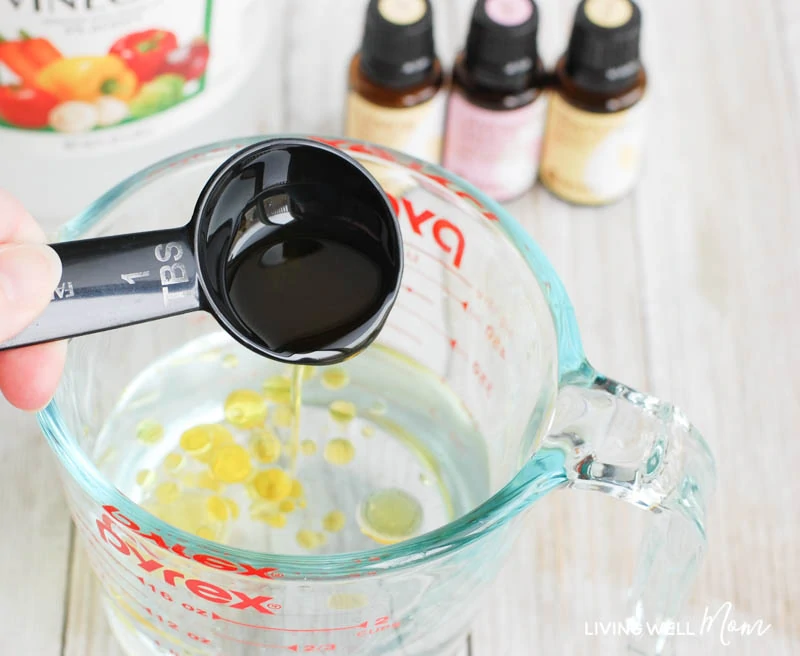 Adding olive oil into a measuring cup of water