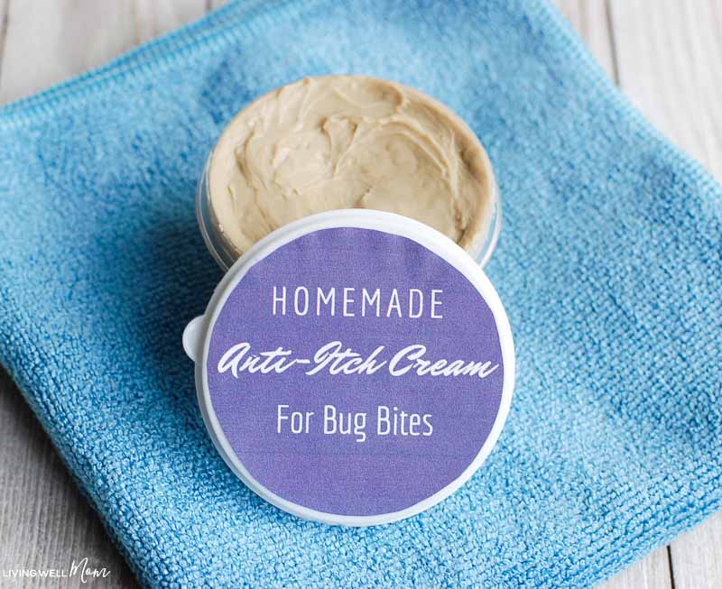 homemade anti-itch cream for bug bites with purple label container on blue towel