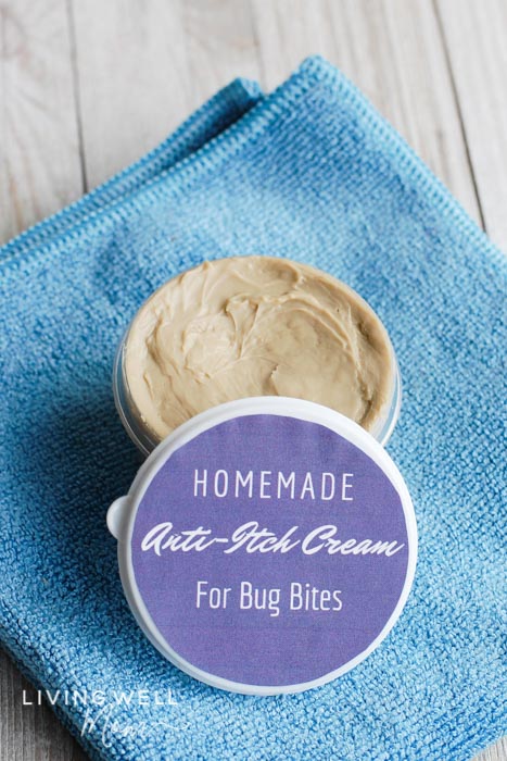 An open jar of DIY insect bite cream with a paper label on the lid. 