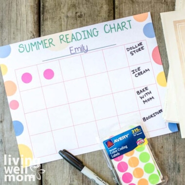 colorful printed reading chart with books, marker, and bright dot stickers on wood background