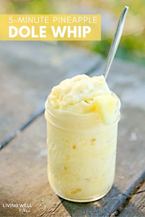 Pineapple ice cream in a glass jar with a spoon inside. 