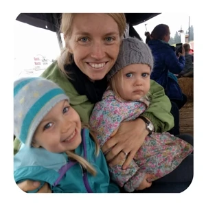 a woman holding two little girls in her arms