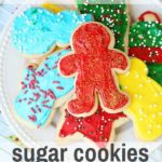 frosted gluten-free sugar cookies on a plate with Christmas sprinkles