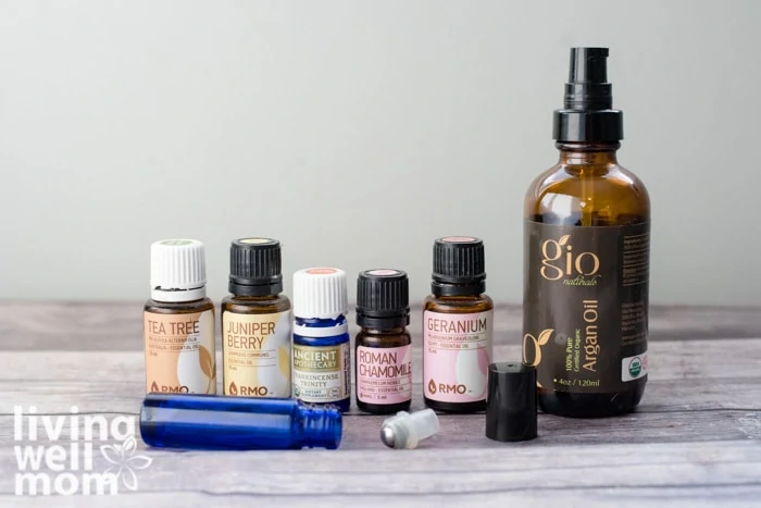 essential oil bottles, argan oil, and roller bottle on table