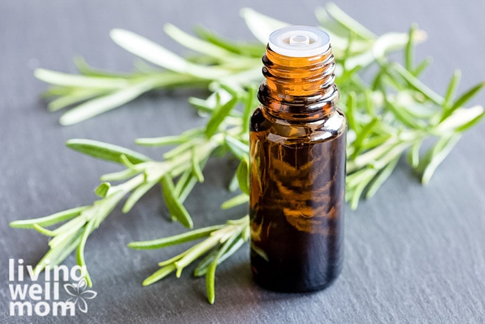 rosemary leaves with glass essential oil bottle